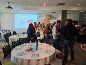 Dejeuner CPME 91 avec des personnes debout discutant autour de table pour déjeuner.