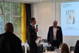 Dejeuner CPME 91 avec présentation sur l'écran en arrière plan, 1 homme avec micro et 1 autre homme debout à coté. L'audience est autour de table de déjeuner.
