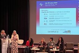 Scène des 30 de CAP Emploi 78 - IHY au Campus Oxygène Factory – Les Mureaux. 1 homme debout au pupitre, 1 femme debout à coté lisant son texte, 4 femmes assises, 1 présentation projetée en arrière plan sur l'écran
