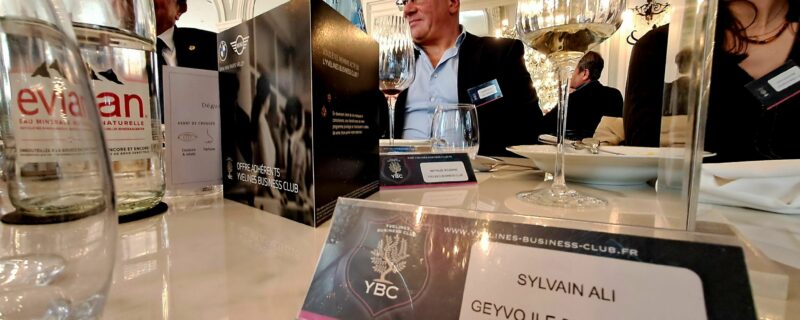 prise de vue de Sylvain Ali, chargé de développement essonne geyvo ile de france. premier plan etiquette sylvain ali geyvo ile de france. arrière plan autres convives à table.